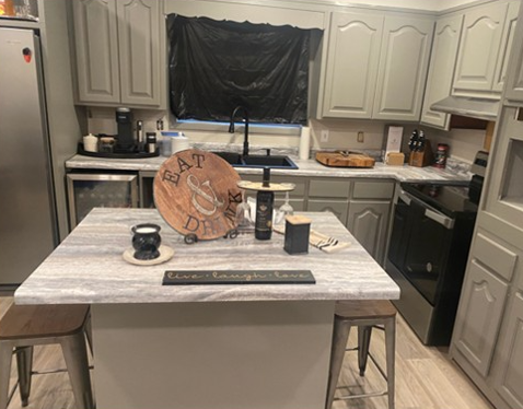 Modern kitchen remodel with gray cabinets, white countertops, and kitchen island