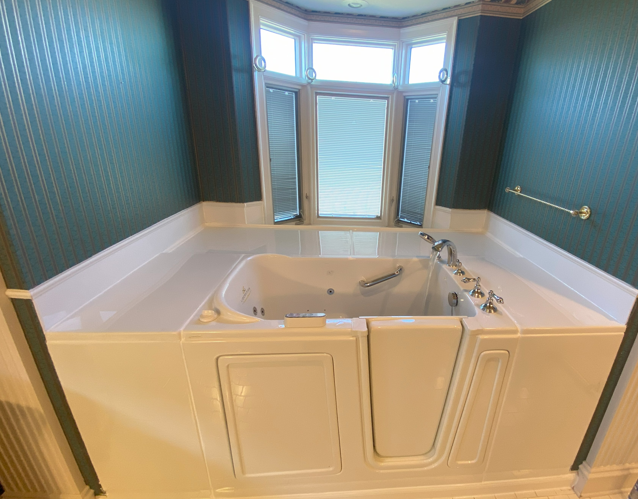 Walk-in tub installation in master bathroom with bay window and safety features